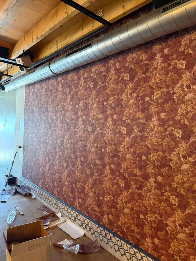 Wand met koperkleurig patroonbehang