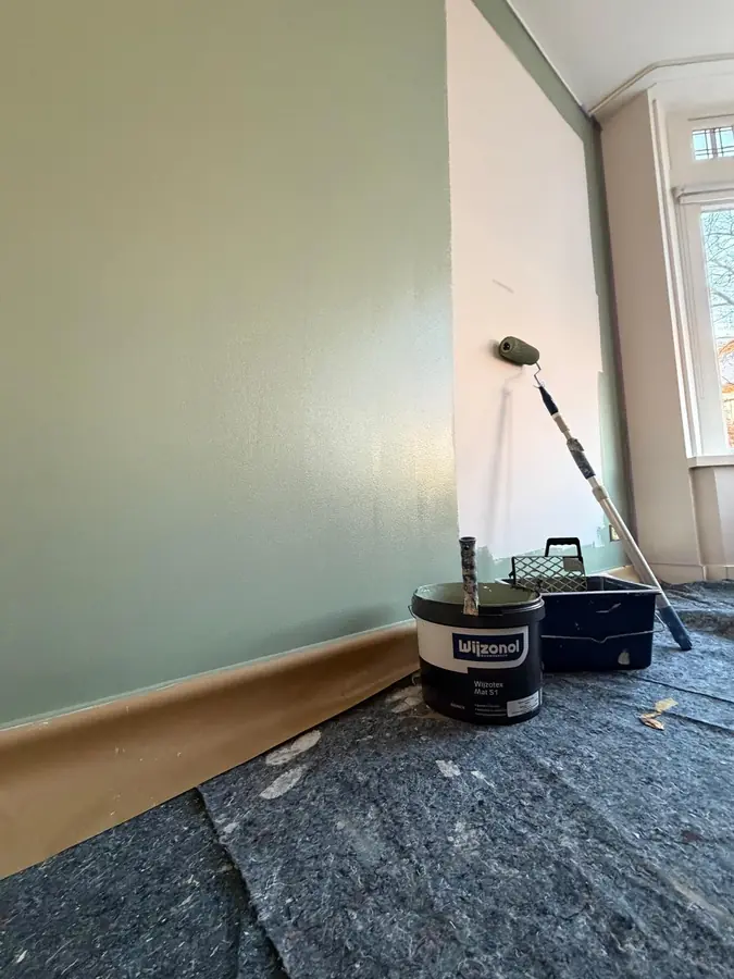 Wand schilderen in een groene kleur, met roller en verf