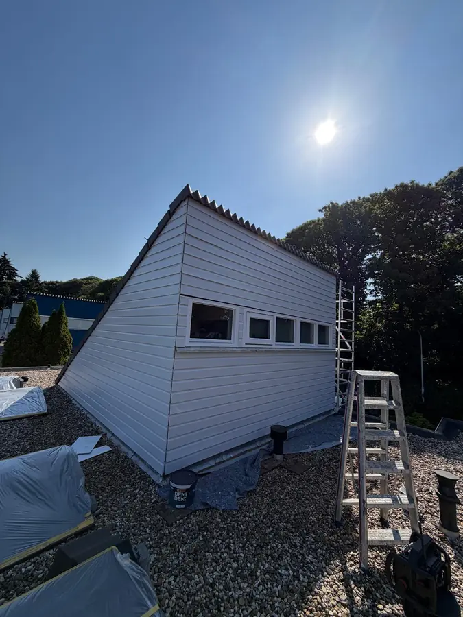 Buitenschilderwerk aan een dakopbouw in uitvoering